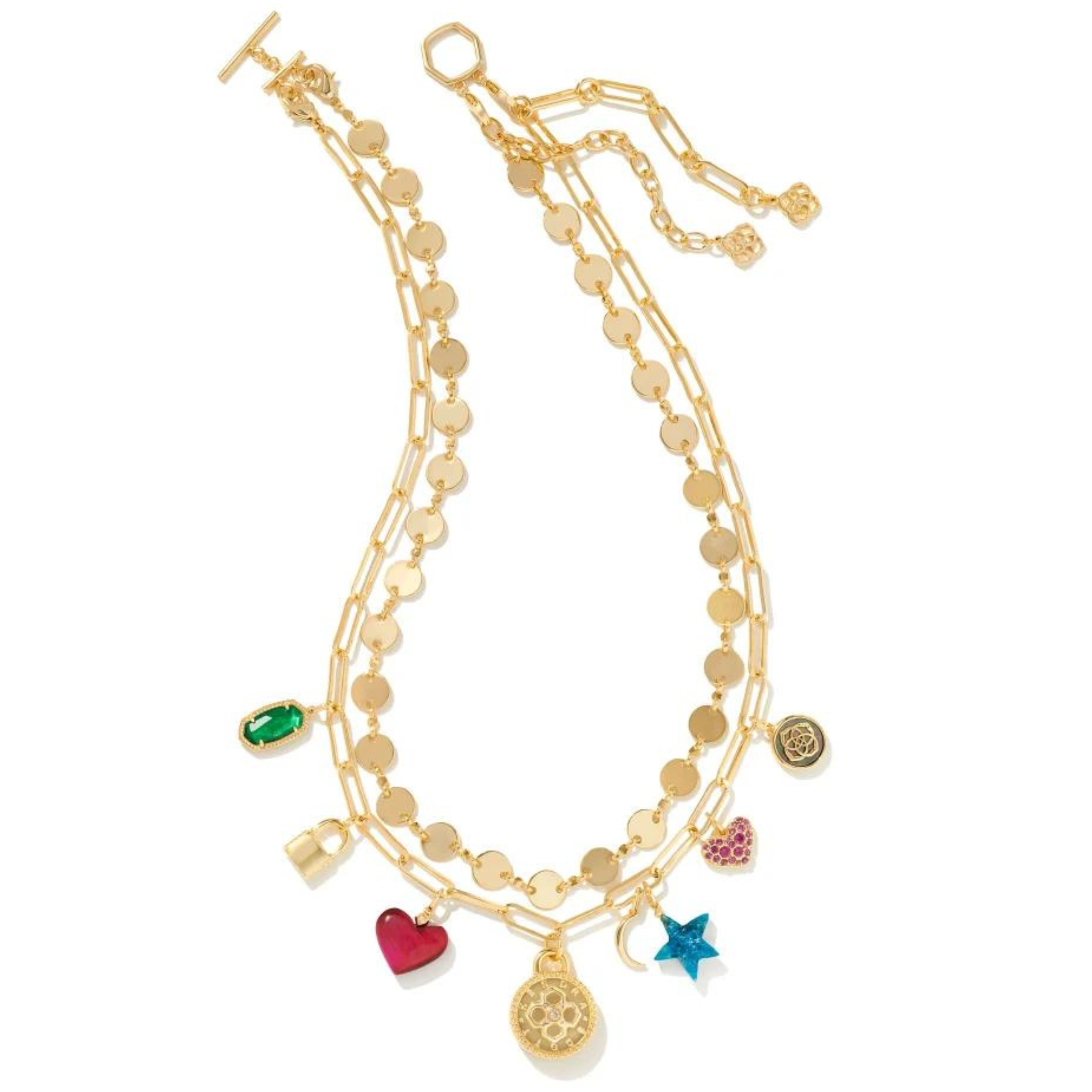 Double layered gold necklace. One layer has multicolored charms in different designs. These charms include a green oval, gold lock, pink heart, blue star, blue moon, and pink crystal heart. This necklace is pictured on a white background. 