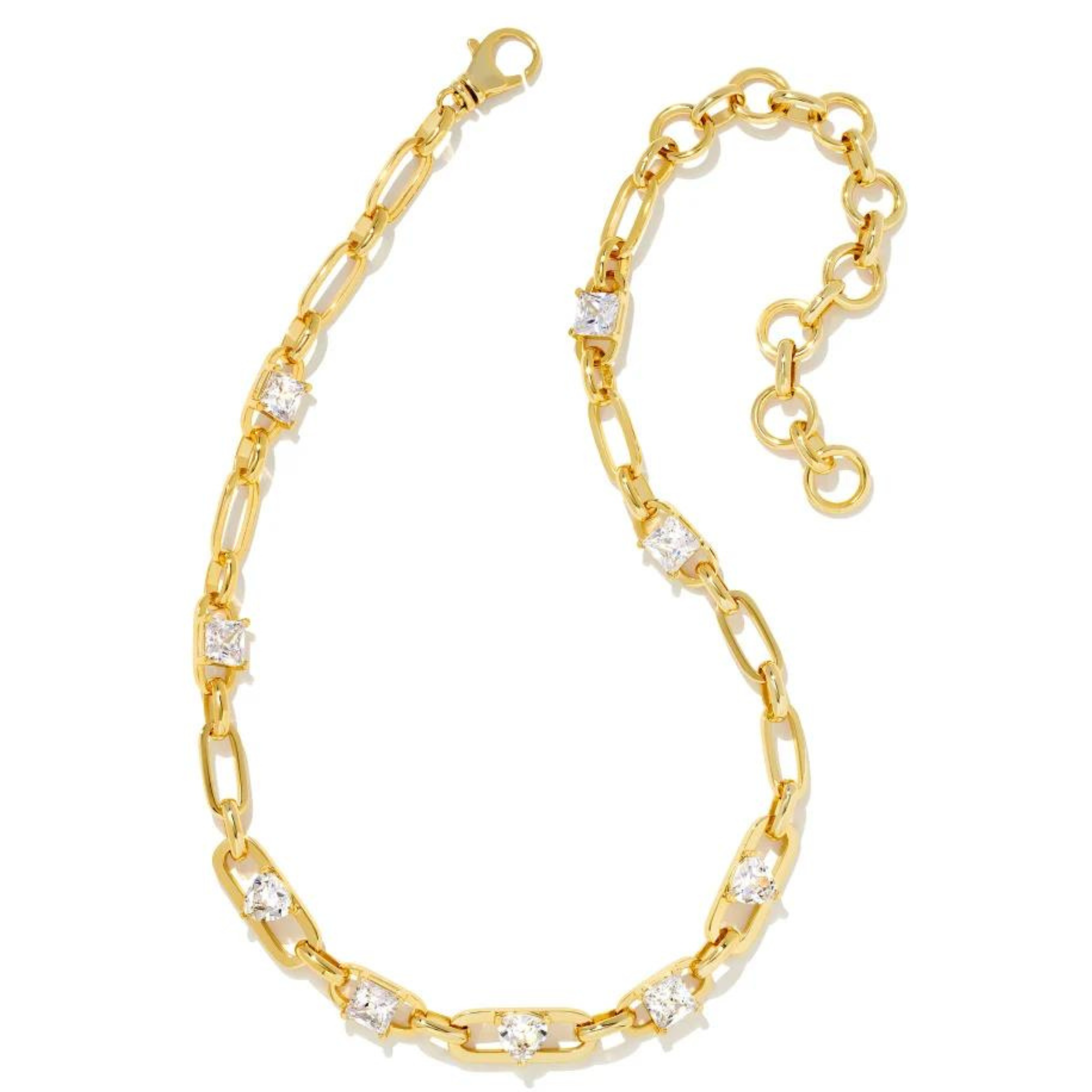 Gold chain necklace with different shaped clear crystals throughout the necklace. This necklace is pictured on a white background. 