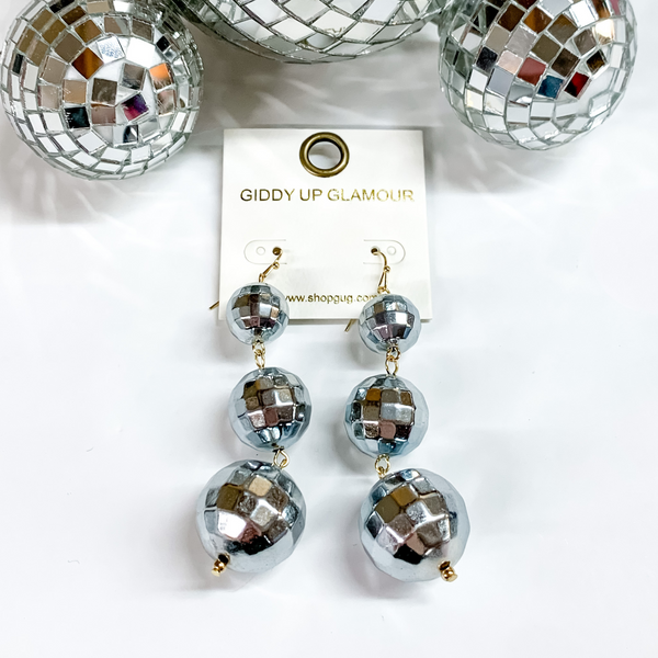 Three disco ball drop earrings in silver grey. These disco balls are in order of smallest to biggest at the bottom. These earring are pictured on a white background with disco balls at the top of the picture. 