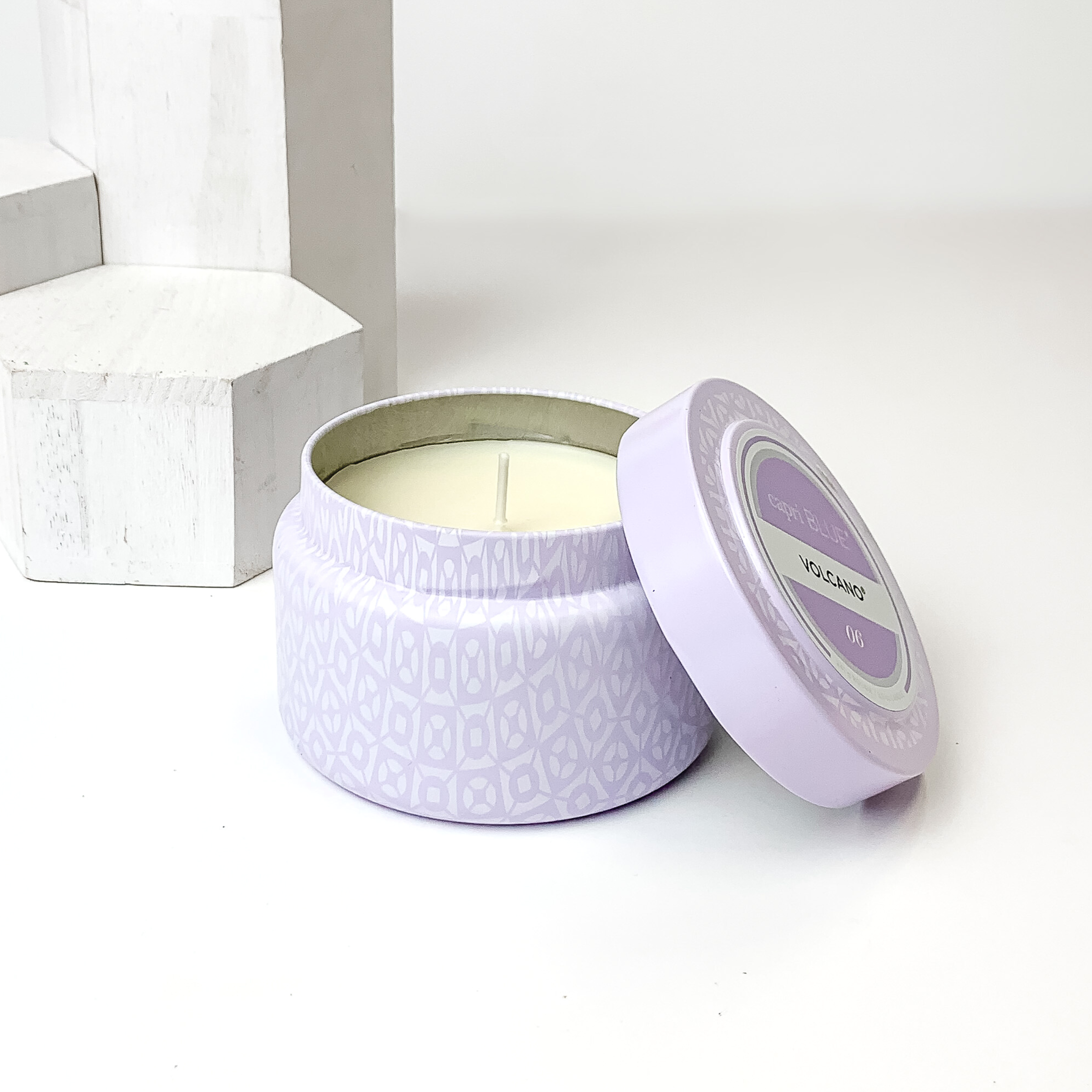 Light lavender printed candle with a matching lid. This candle is pictured on a white background with white blocks on the left side of the candle. 