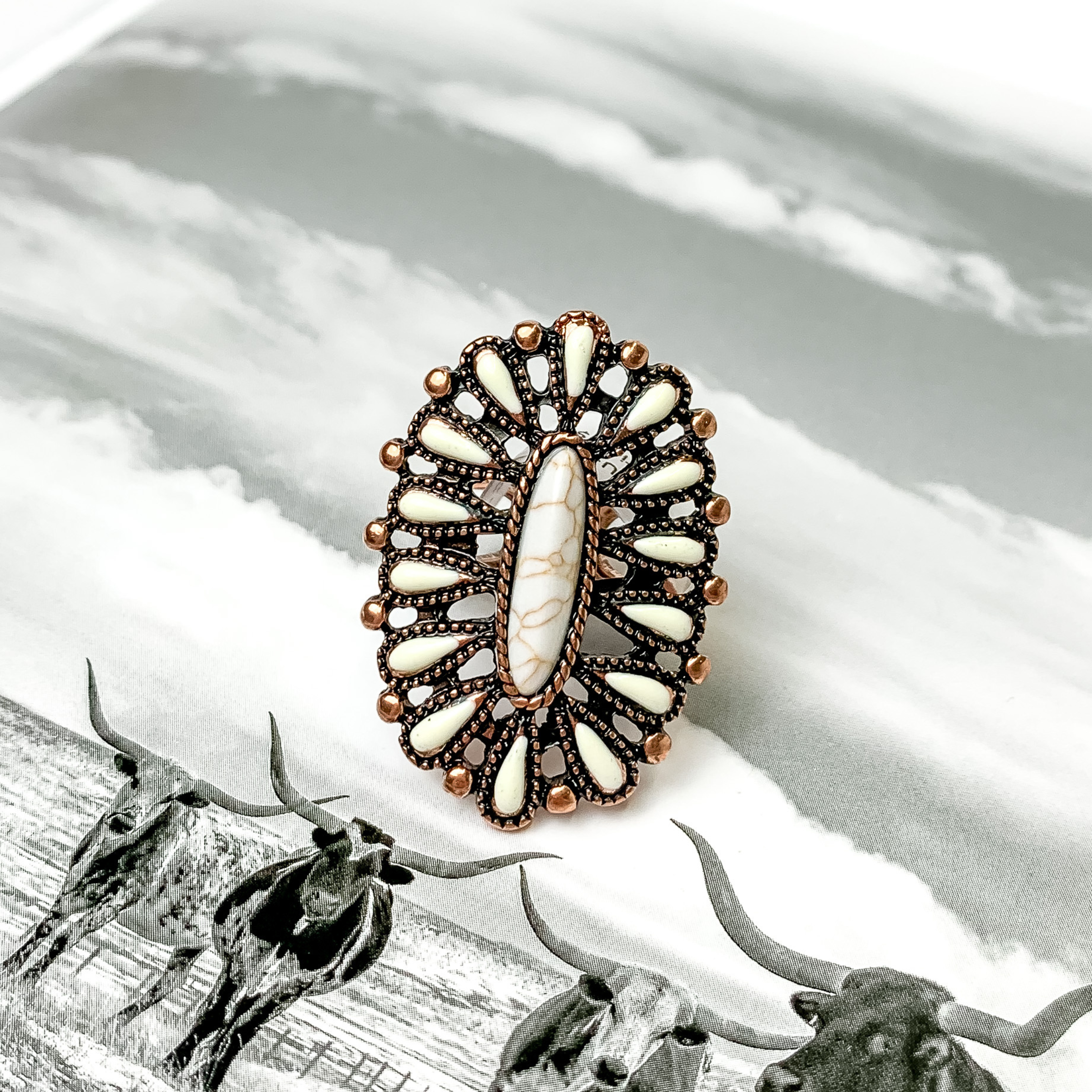 Oval ivory cluster ring in copper. This ring is pictured on a black and white picture. 