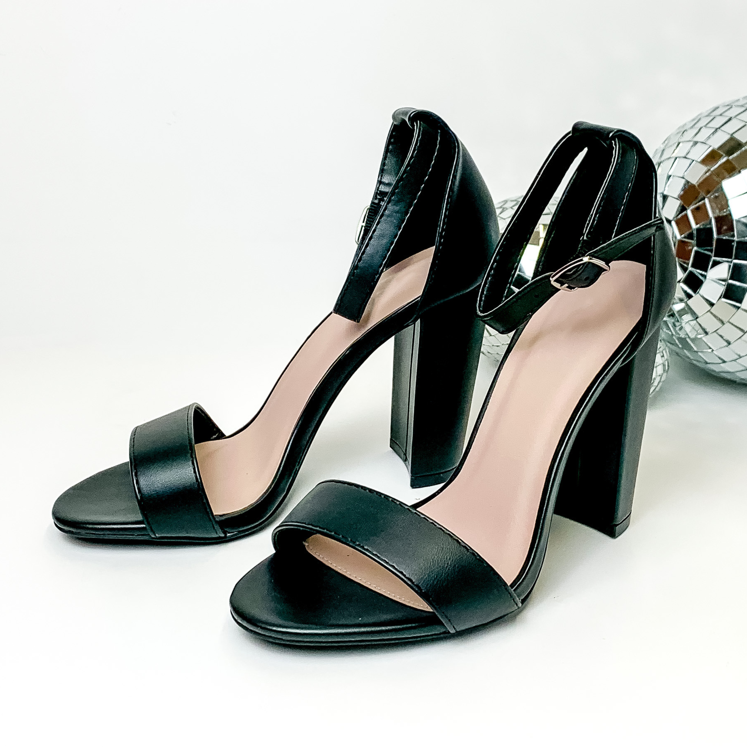 Black, block high heel sandals with an adjustable strap. These heels are pictured on a white background with disco balls on the right side of the heels. 