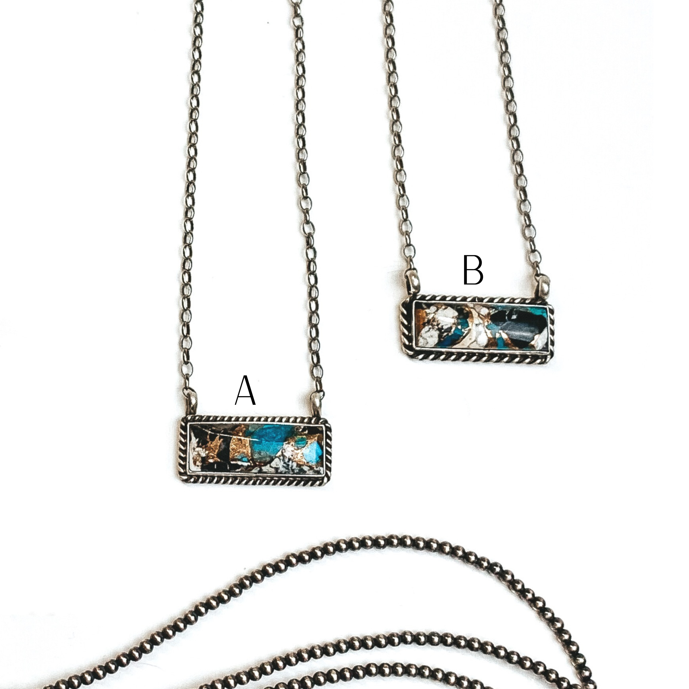 Two silver chain necklaces with rectangle bars that have a white buffalo and turquoise remix stone. These necklaces are pictured on a white background with silver beads under the necklaces.