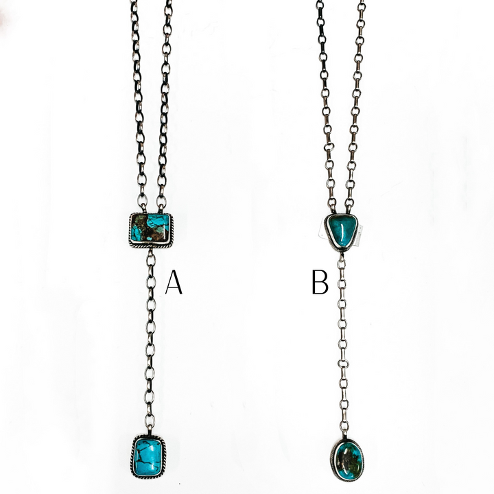 Two silver chain lariat necklace with two turquoise stones. This necklace is pictured on a white background. 