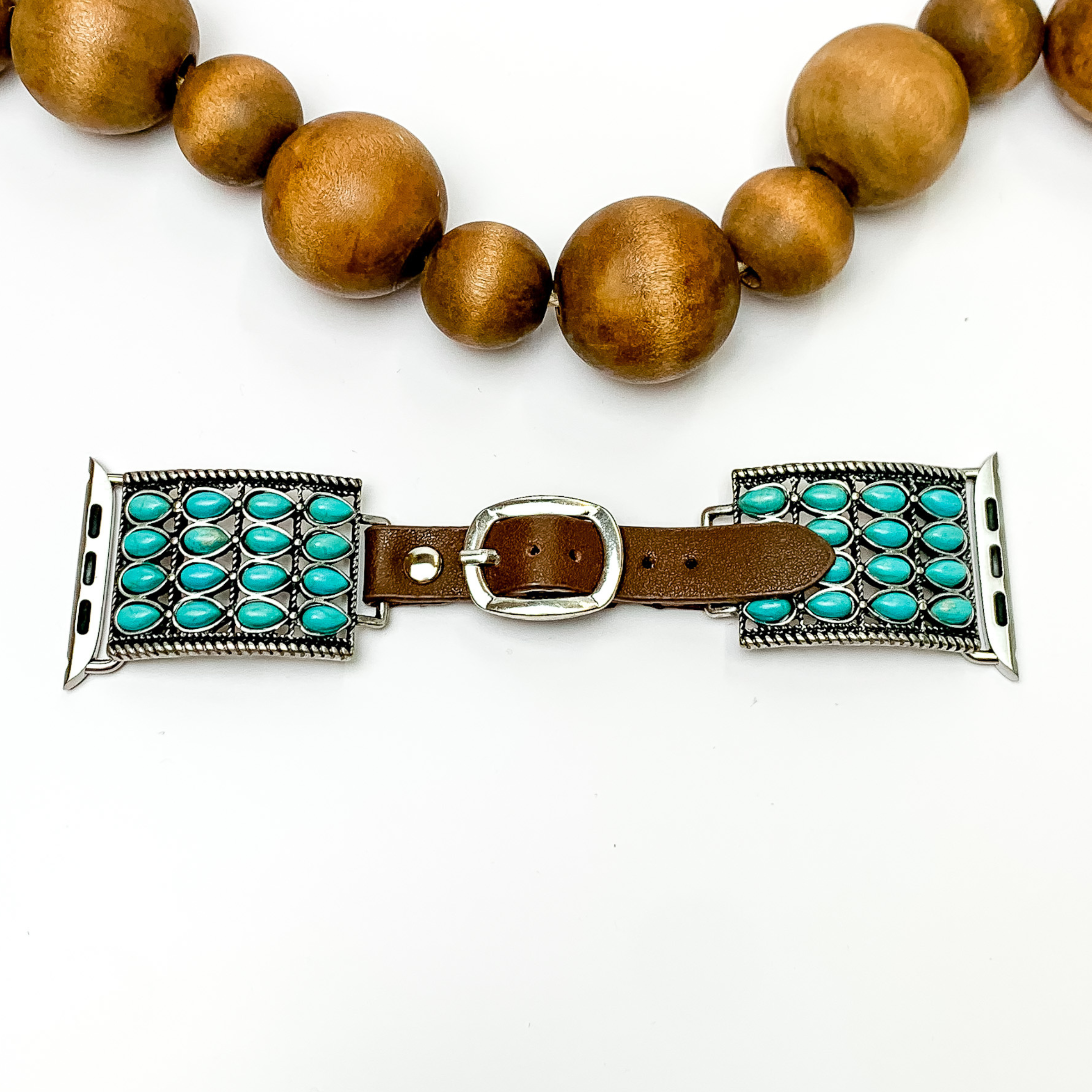 Dark Brown watch band with silver, engraved rectangle pendants and Apple watch band acessories. The pendants include rows of 16 turquoise stones. This watch band is pictured on a white background with brown beads above the band. 