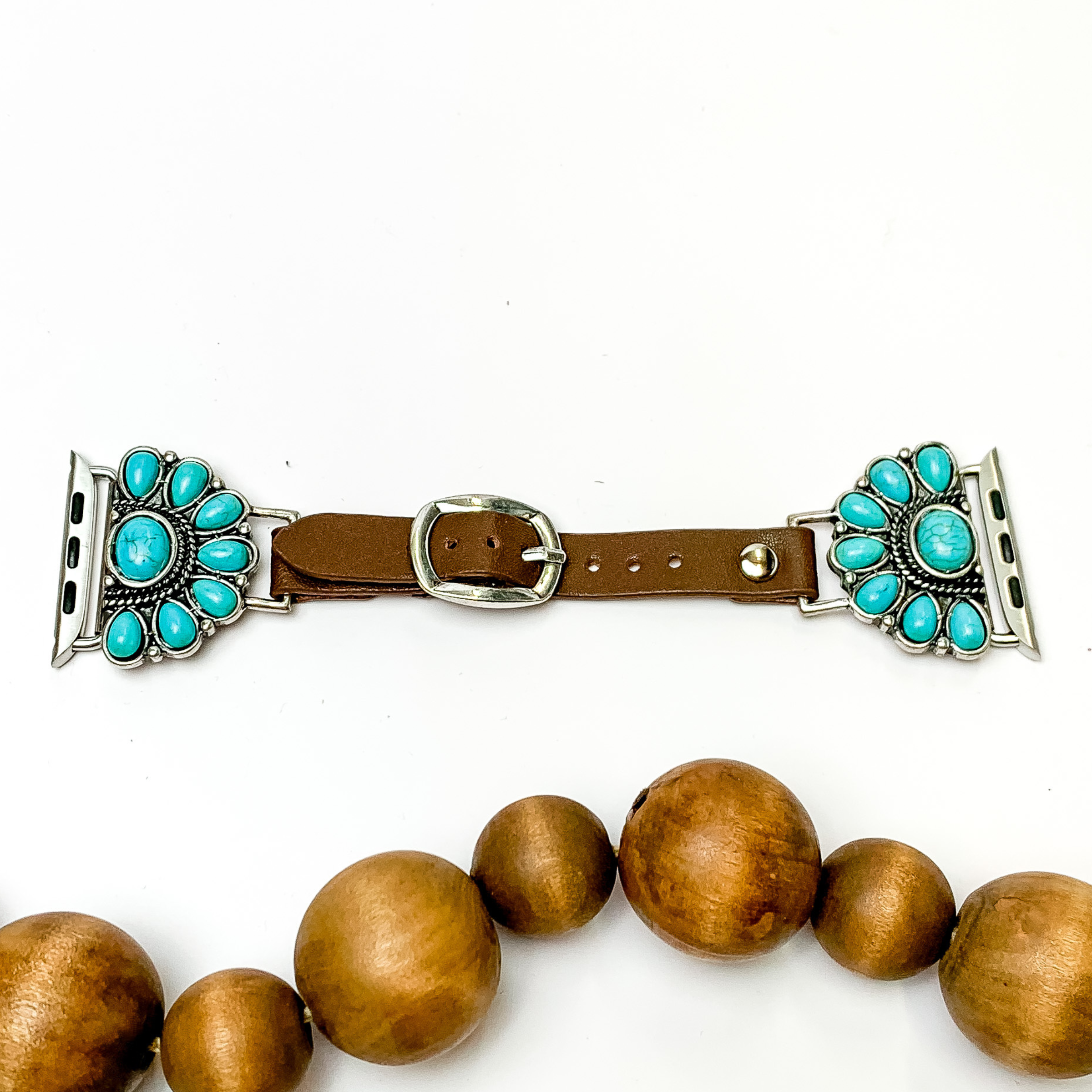 Dark Brown watch band with half, stone cluster pendants and Apple watch band acessories. The pendants include turquoise stones. This watch band is pictured on a white background with brown beads below the band. 