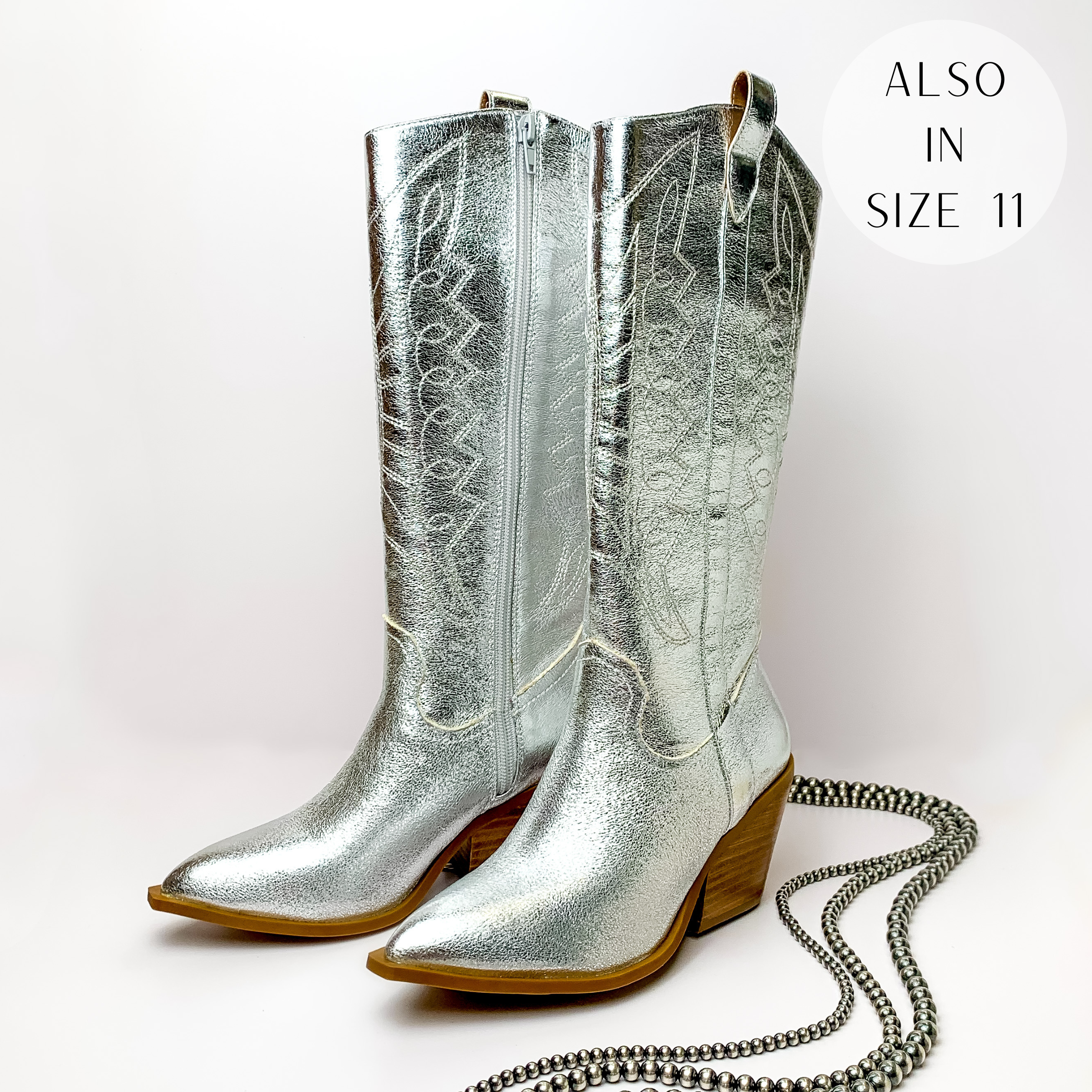 Metallic silver cowboy boots with silver western stitching and tan heel. These boots are pictured on a white background with silver beads on the right side of the boots.