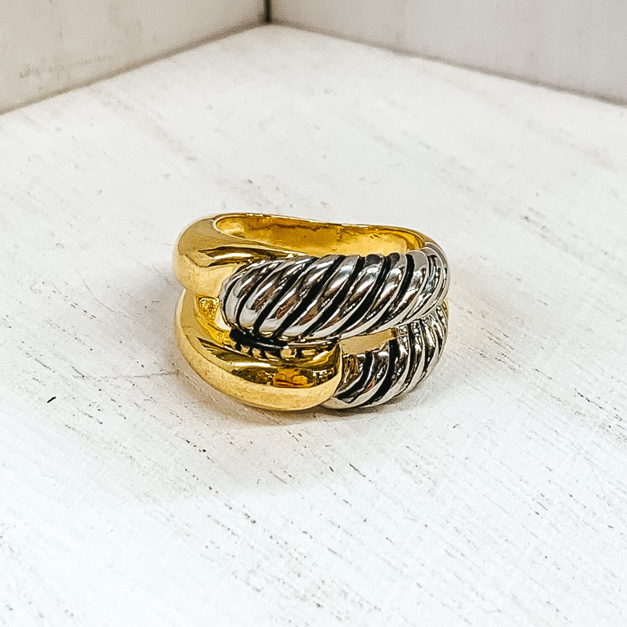 Gold and silver knot ring. The silver part is a twisted design. This ring is pictured on a white background. 