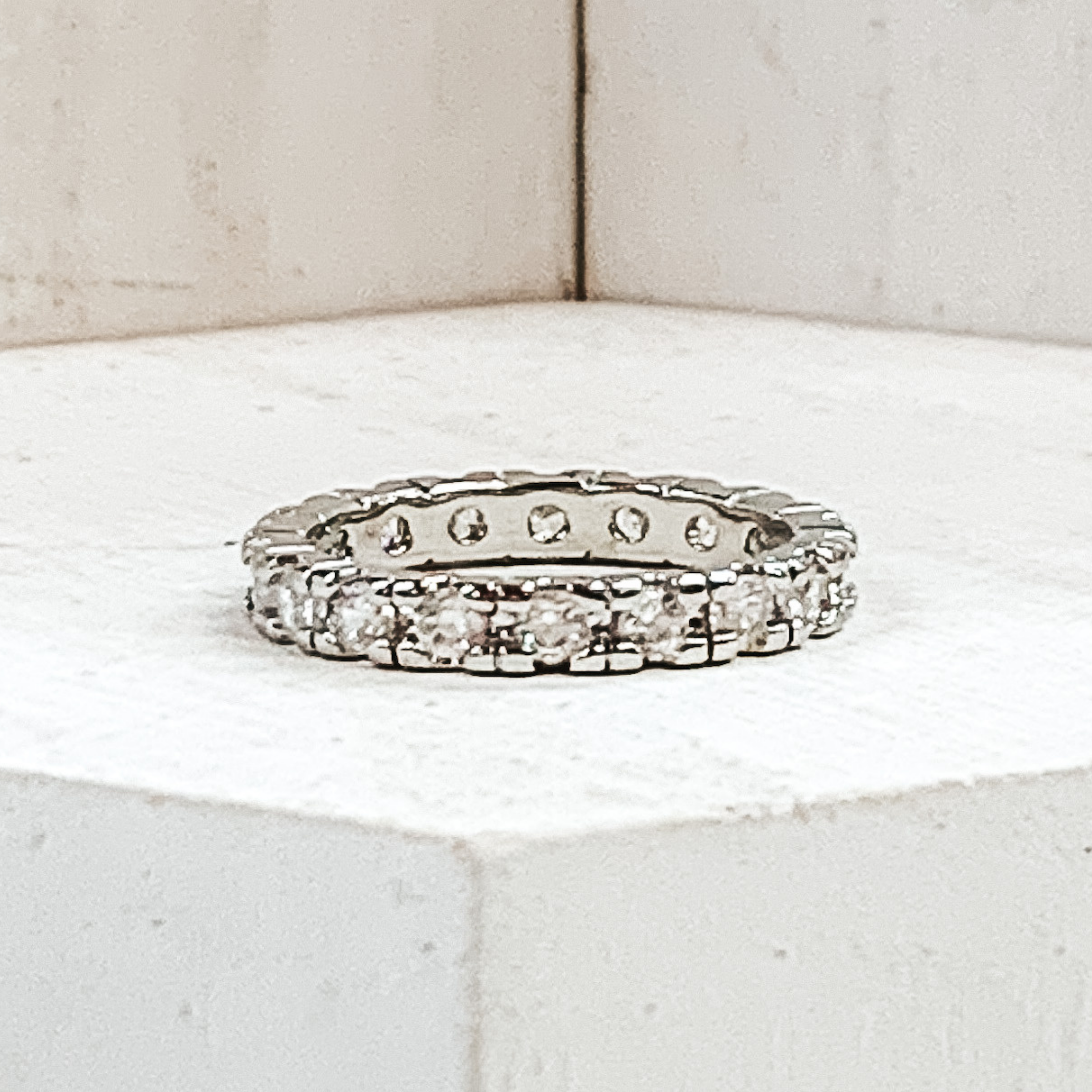 Silver ring with center clear crystals in each segment. This ring is pictured on a white background.