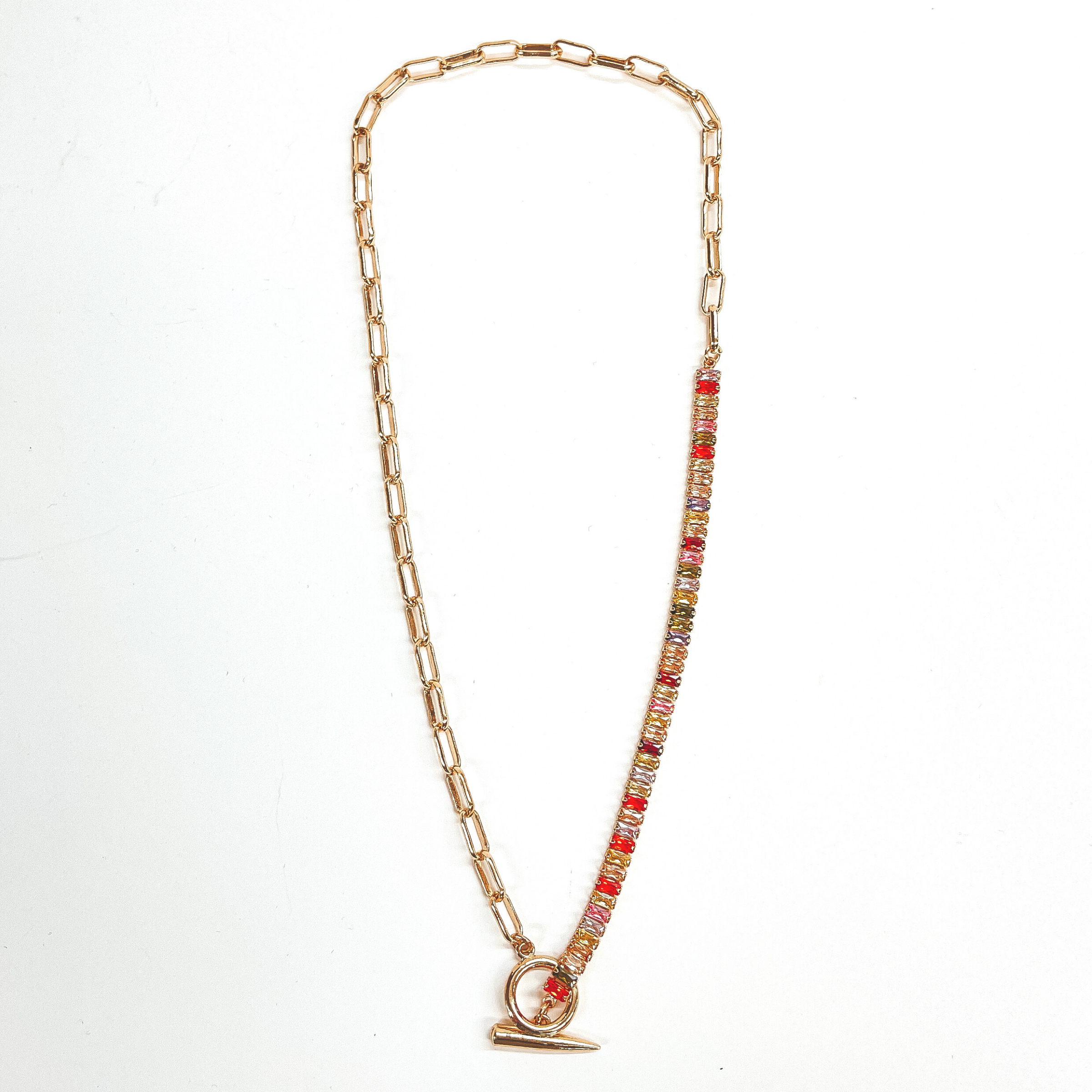 This gold necklace is half multicolored rhinestones  and half paperclip chain. The multicolored  rhinestones are orange, red, yellow, light pink, green,  purple, and champagne. There is also a  front toggle clasp. This necklace is pictured on a  white background.
