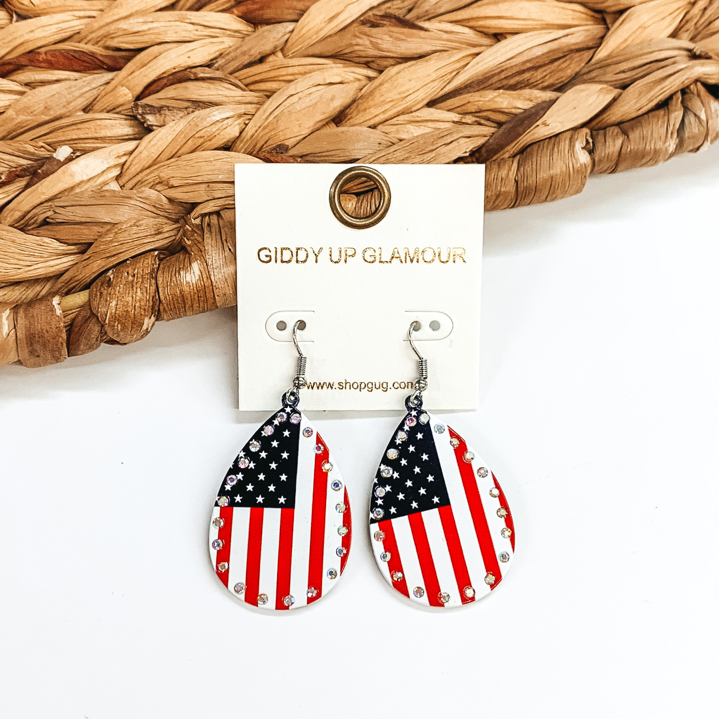 These are teardrop earrings with AB crystals all  around with the American flag.  These earrings are taken on  a white background and leaned up against a brown  woven slate.