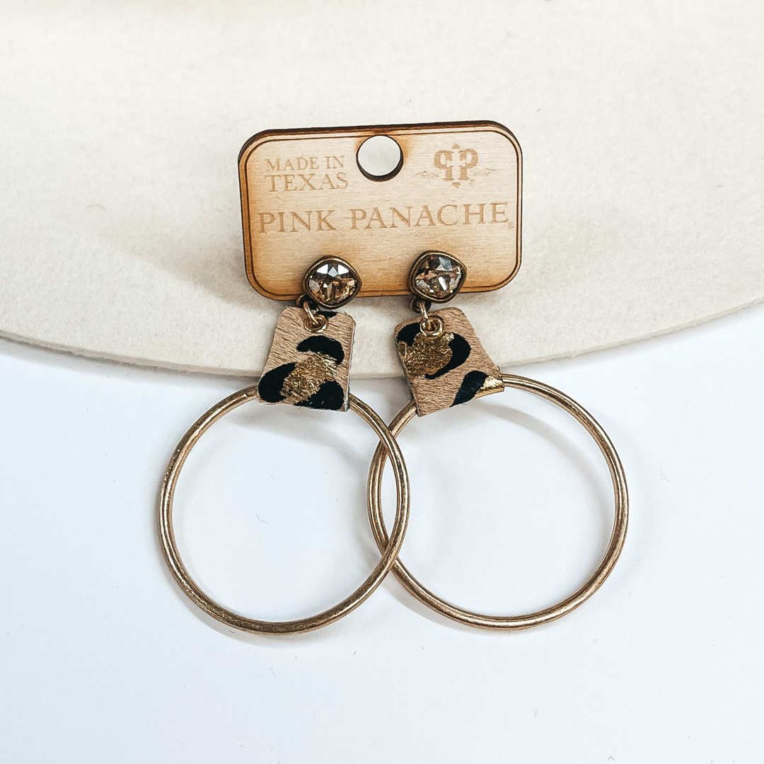 Post back topaz cushion cut crystal with a small piece of faux leather leopard print with gold and a circle drop in matte gold. Taken on a white and ivory  background.