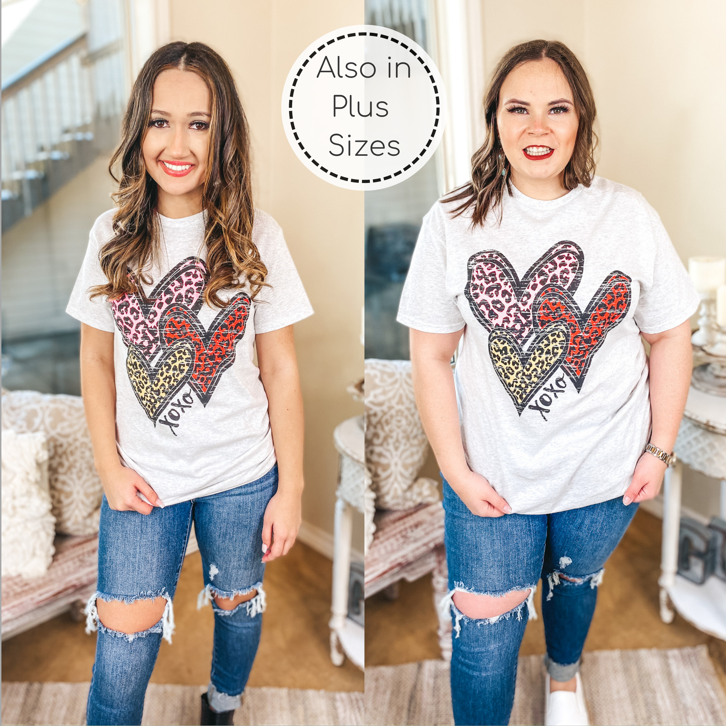 Models are wearing a gray tee with 3 various sized leopard hearts in yellow, pink, and red. Models have this tee paired with skinny jeans and sneakers. Background is hues of white and tan. 