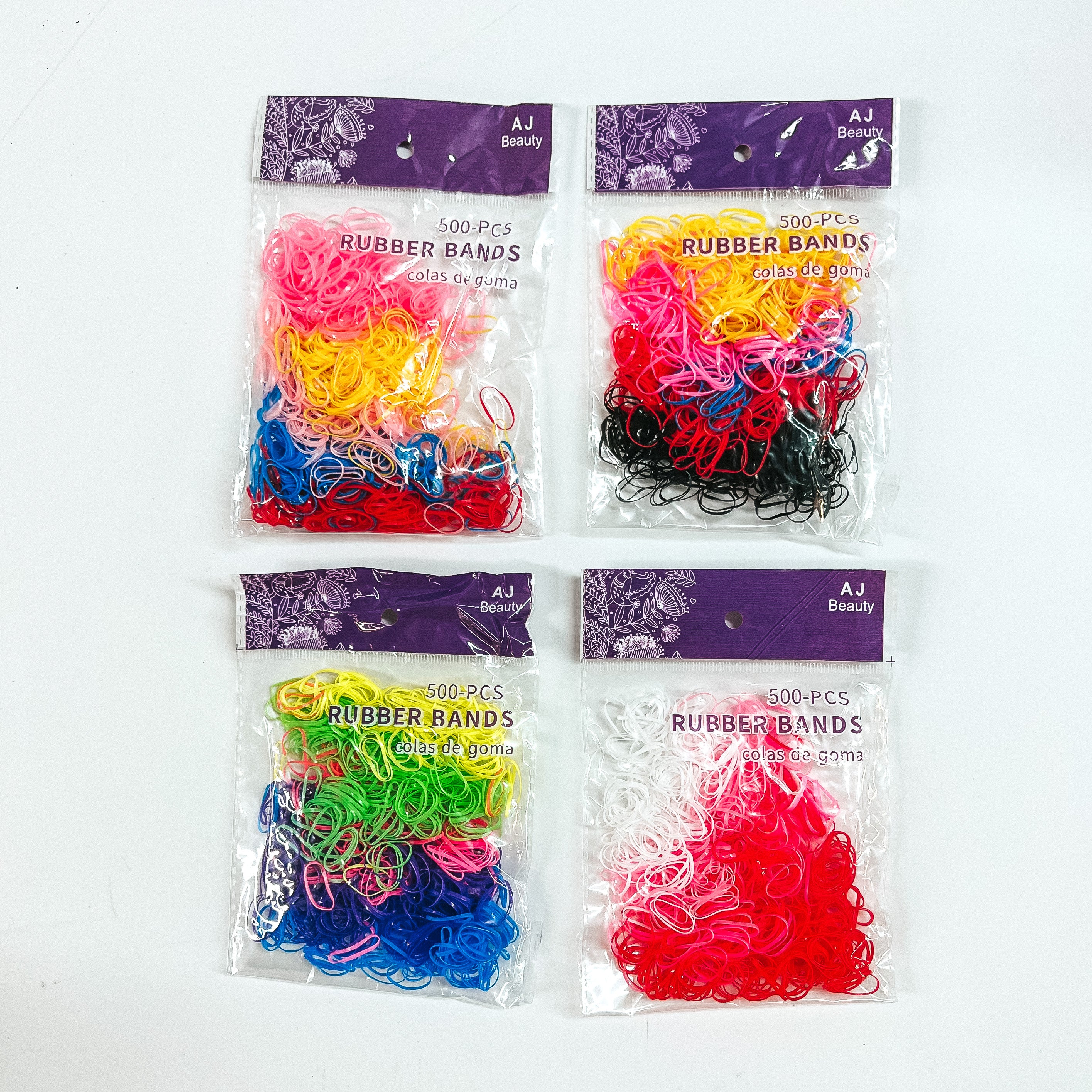There are four packs of multicolored small rubber bands. From top to bottom; pink/yellow/blue/red, yellow/pink/blue/red/black. Neon yellow/neon green/pink/dark blue/ blue and white/pink/red. These rubber bands are placed in a clear and purple bag laying on a white background.