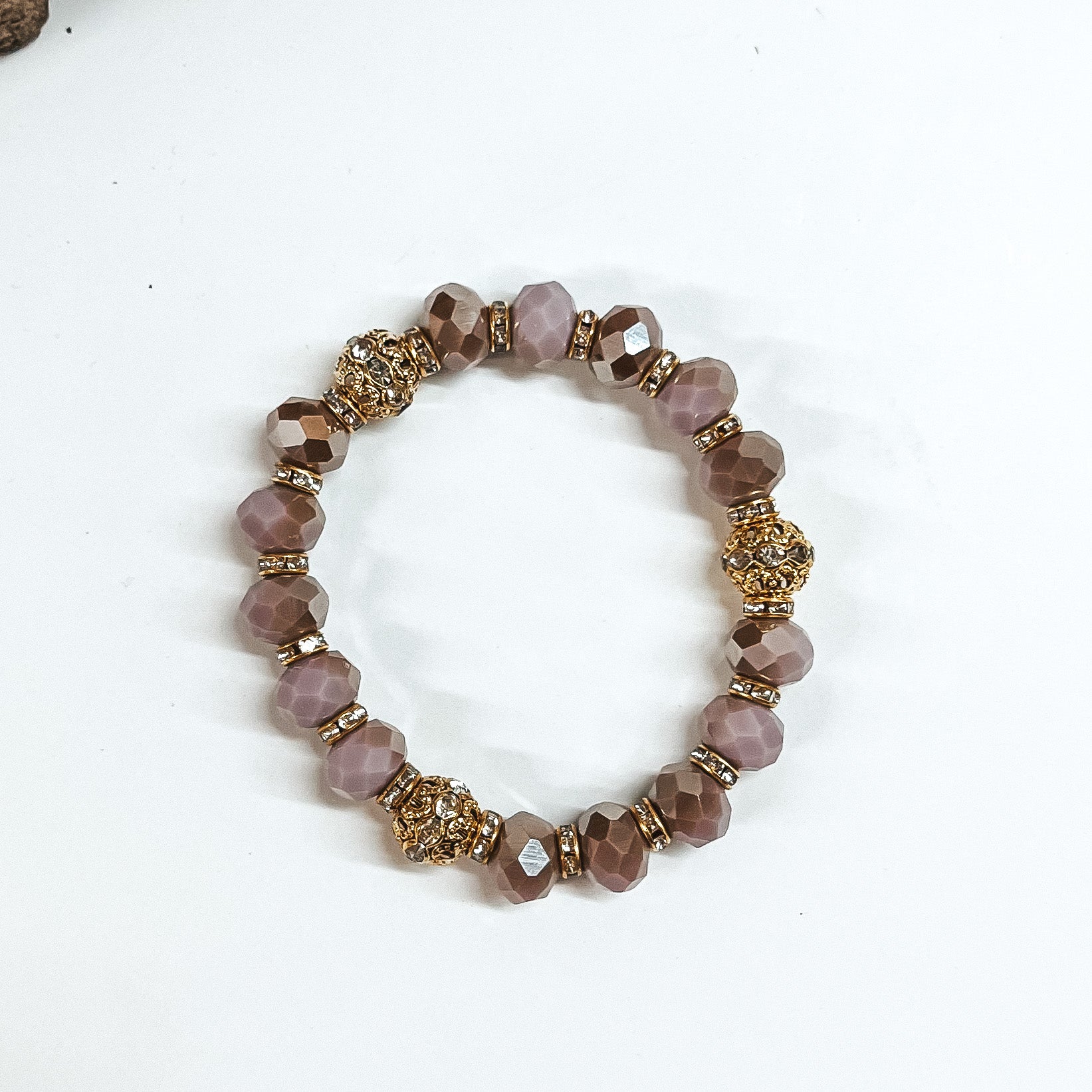 This is lilac/mauve mix crystal beaded bracelets with gold spacers.  The gold spacers have clear crystals in them and there are three gold and  crystals beads.This bracelet is taken on white background.