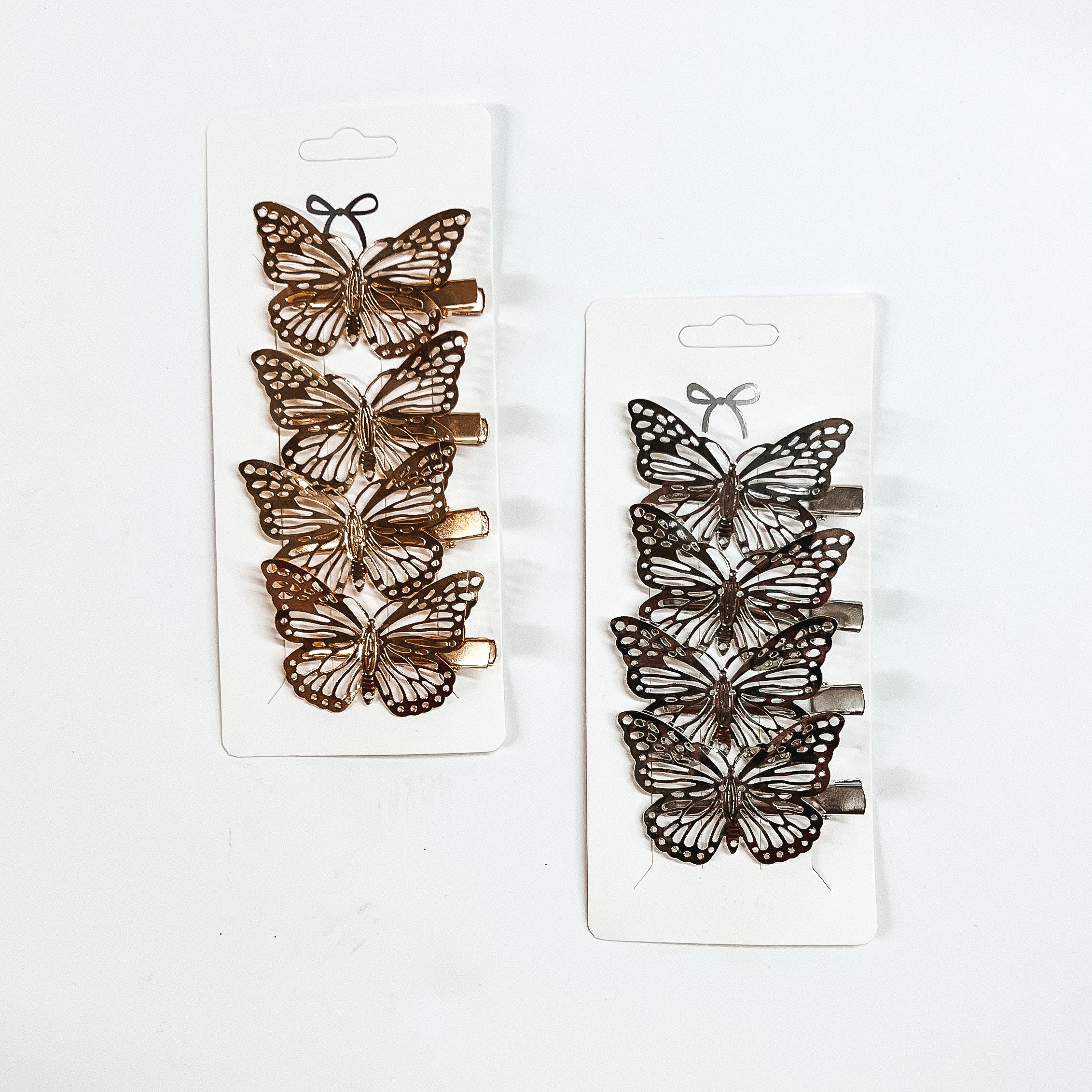 Two sets of four butterfly clips. One set is gold and one set is silver. These clips are pictured on a white background. 