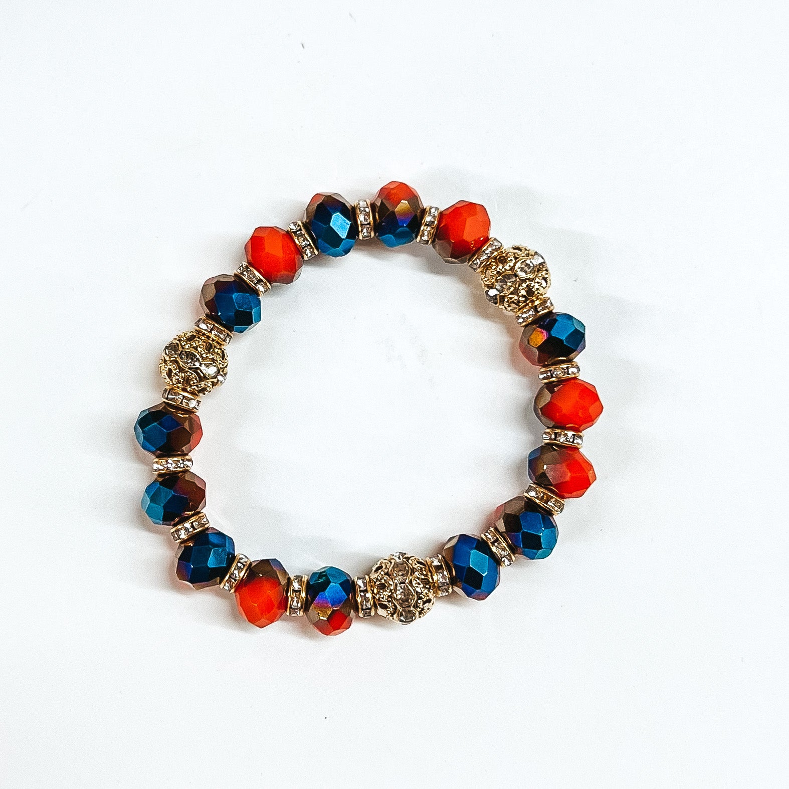 This is blue/orange mix crystal beaded bracelets with gold spacers.  The gold spacers have clear crystals in them and there are three gold and  crystals beads.This bracelet is taken on white background.