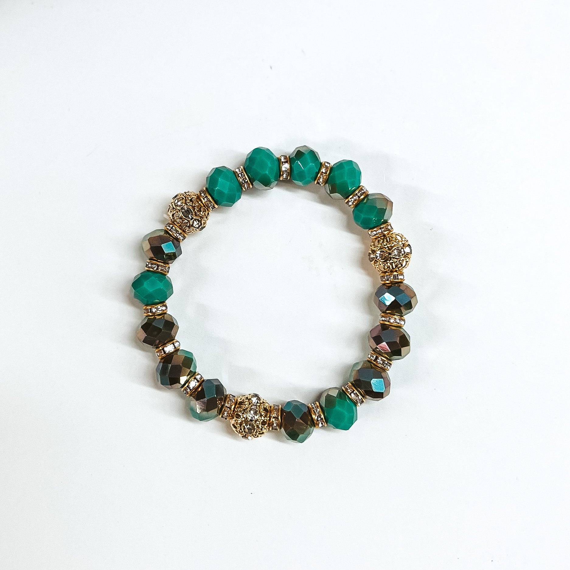 This is green/teal mix crystal beaded bracelets with gold spacers.  The gold spacers have clear crystals in them and there are three gold and  crystals beads.This bracelet is taken on white background.