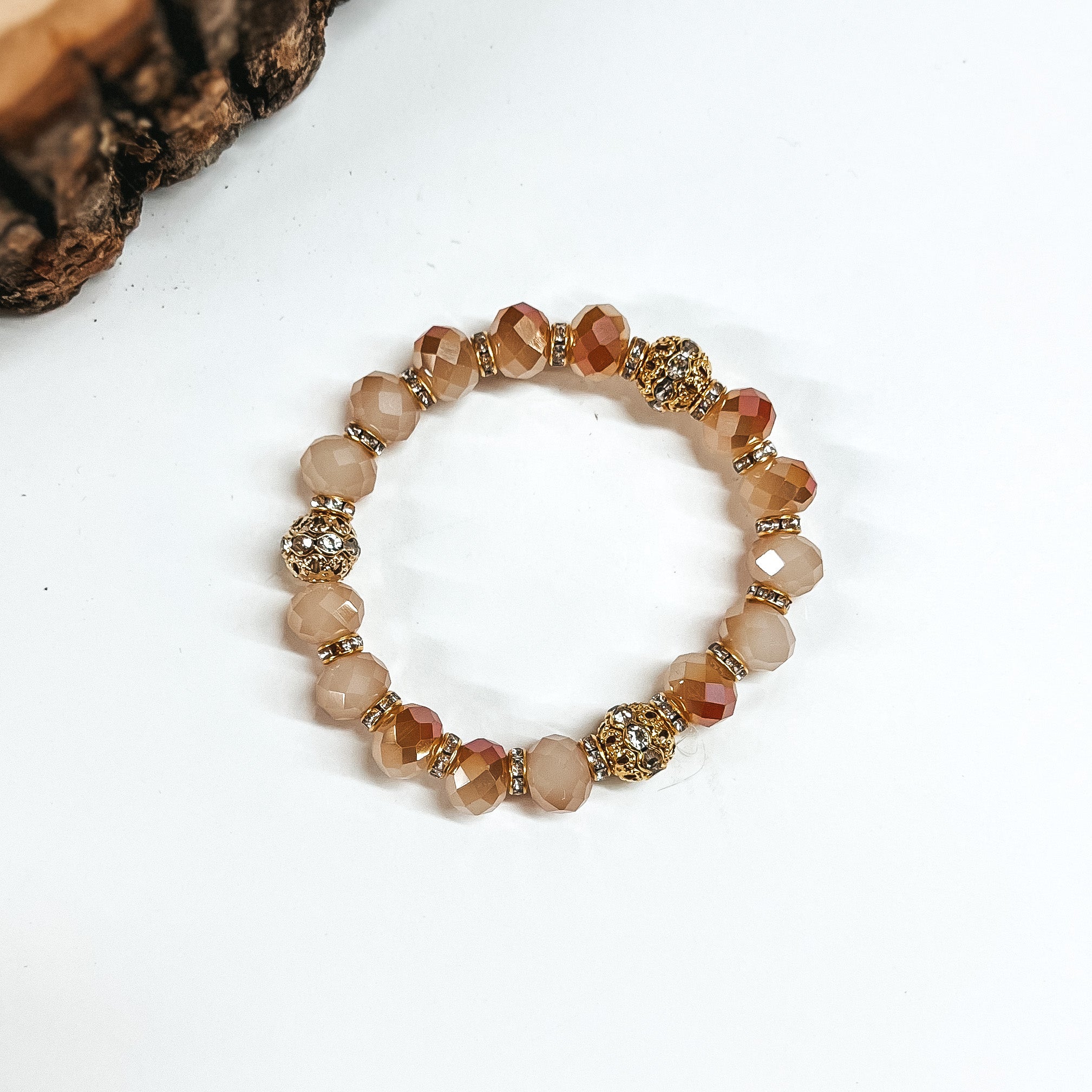 This is light brown crystal beaded bracelets with gold spacers.  The gold spacers have clear crystals in them and there are three gold and  crystals beads.This bracelet is taken on white background.
