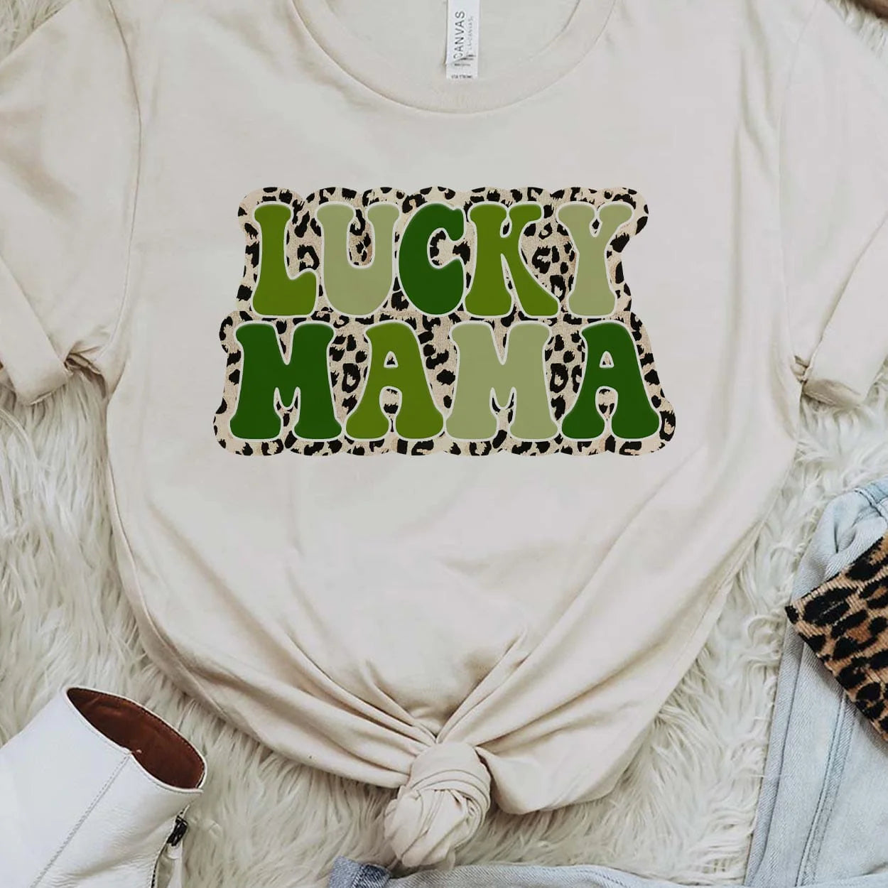 A white crew neck sweatshirt featuring the words "Lucky mama" in various shades of green with a small leopard border around the text. Item is pictured on a white background.