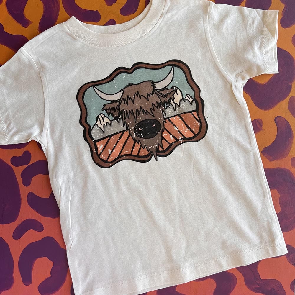 Online Exclusive | Highland Cow and the Mountains Short Sleeve Graphic Tee in Cream - Giddy Up Glamour Boutique