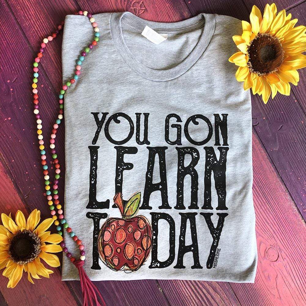 This Grey Bella + Canvas tee includes a crew neckline, short sleeves, and a "you gon learn today" quote with a red and orange polka dot apple replacing the "o" in "Today".